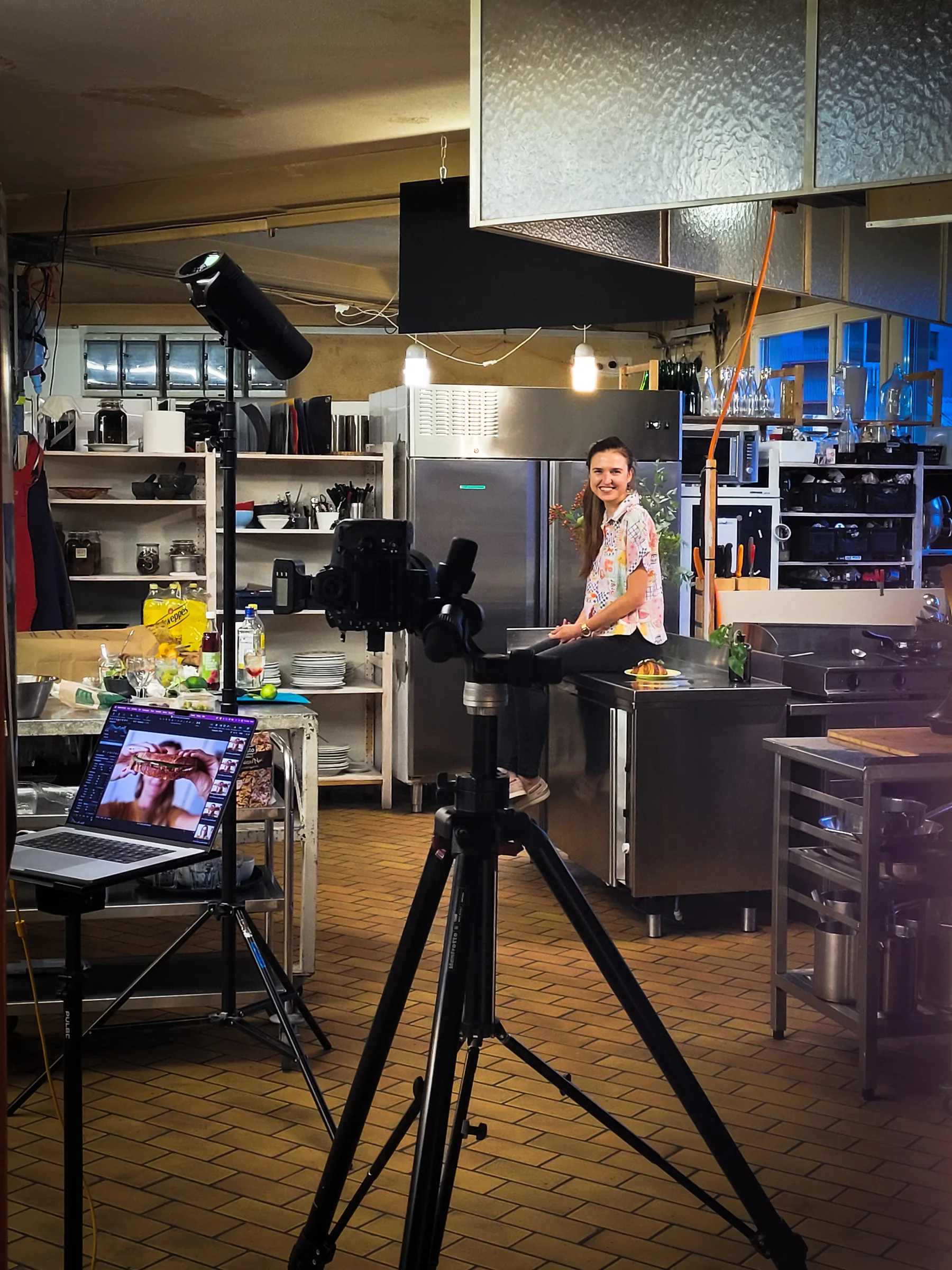 Marta Szumiata during a shoot in a professional kitchen, seated beside a plated dish